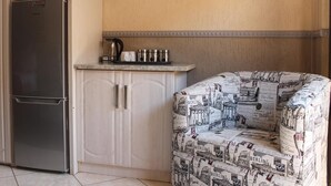Eine Küche mit Kühlschrank, Mikrowelle und Kaffeemaschine auf der Arbeitsfläche.
