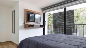 A modern bedroom with a large bed, a mounted TV, and a balcony with blinds. - 3 Bedroom Balcony, 3 Hot Tubs, AC (Medellin)