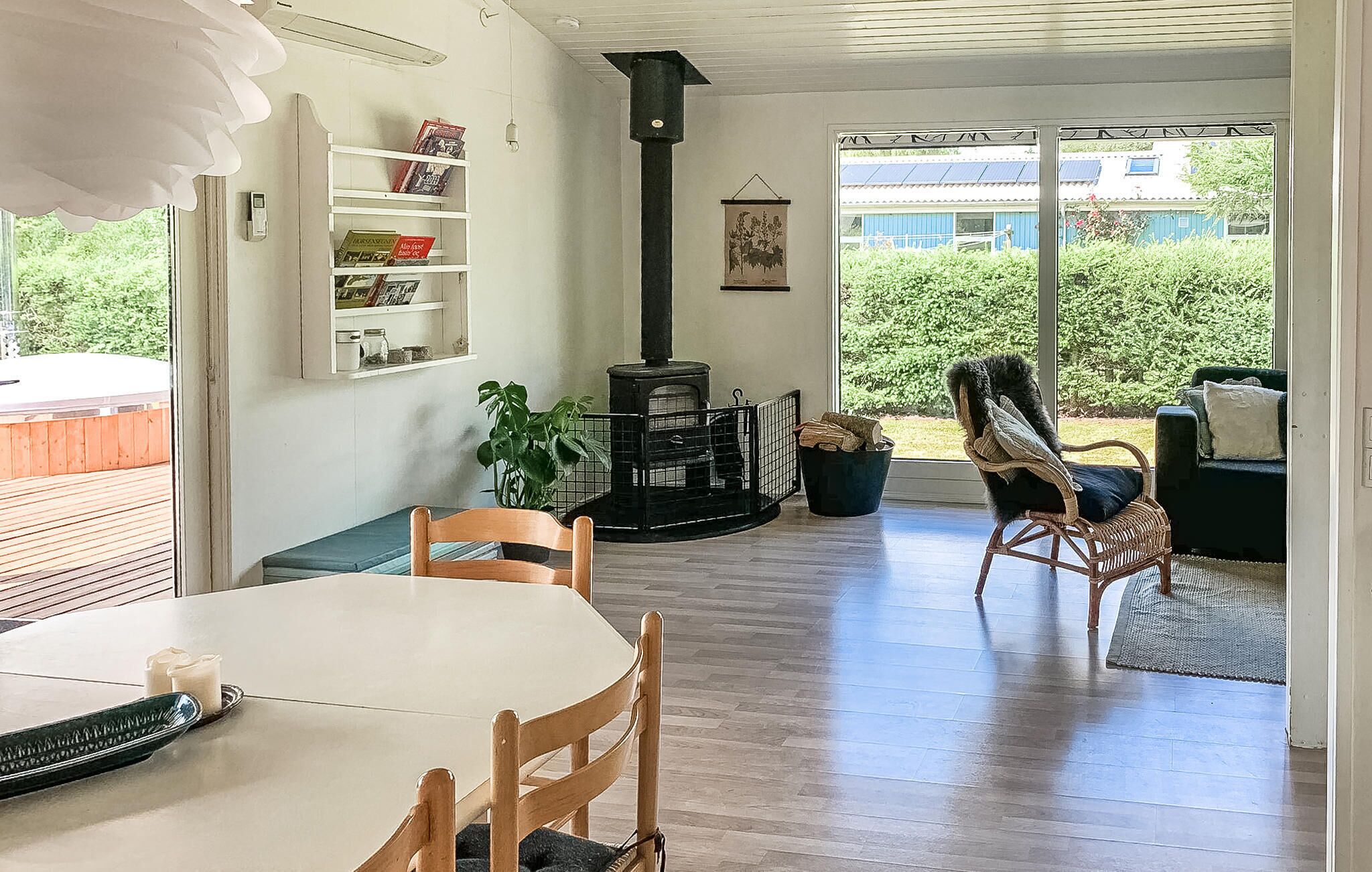 Ett mysigt vardagsrum med en öppen spis, en matplats med bord och stolar samt en bokhylla.