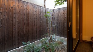 A wooden fence, a small tree, and a gravel path leading to a door. - Jishoan (Kyoto)