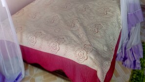 A single bed with a canopy, a patterned bedspread, and a red accent at the foot of the bed. - Aberdare Guest House (Naivasha)