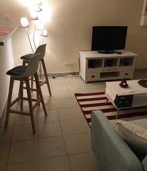 Cozy living space with a dining area, flat-screen TV, and comfortable sofa.