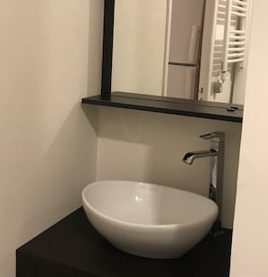 Bathroom features a white sink, faucet, and mirror.