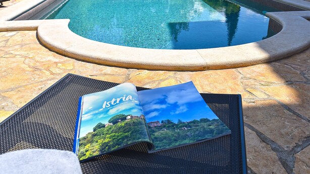 A pool area with lounge chairs and a brochure titled "Istria." - Villa 2019/28699 (Istria - Poreč), 3000m from the beach (Poreč)