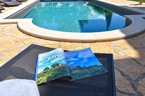 A pool area with lounge chairs and a brochure titled "Istria."