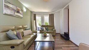 A living room with a sofa, armchair, and coffee table. There is a painting on the wall and a window with curtains. - Villa 2019/28699 (Istria - Poreč), 3000m from the beach (Poreč)