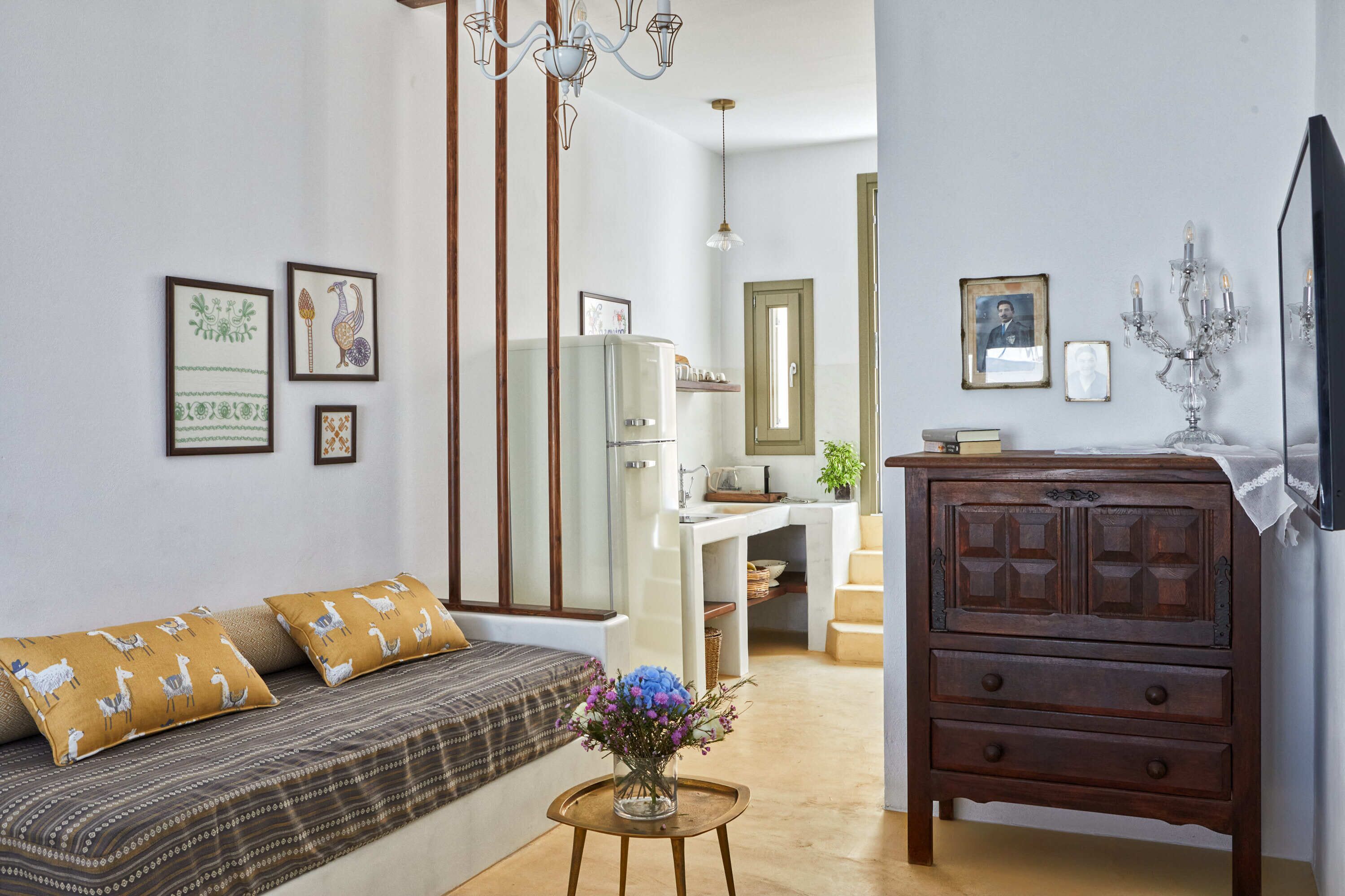 A living room with a sofa, a wooden cabinet, and a small table with a vase.