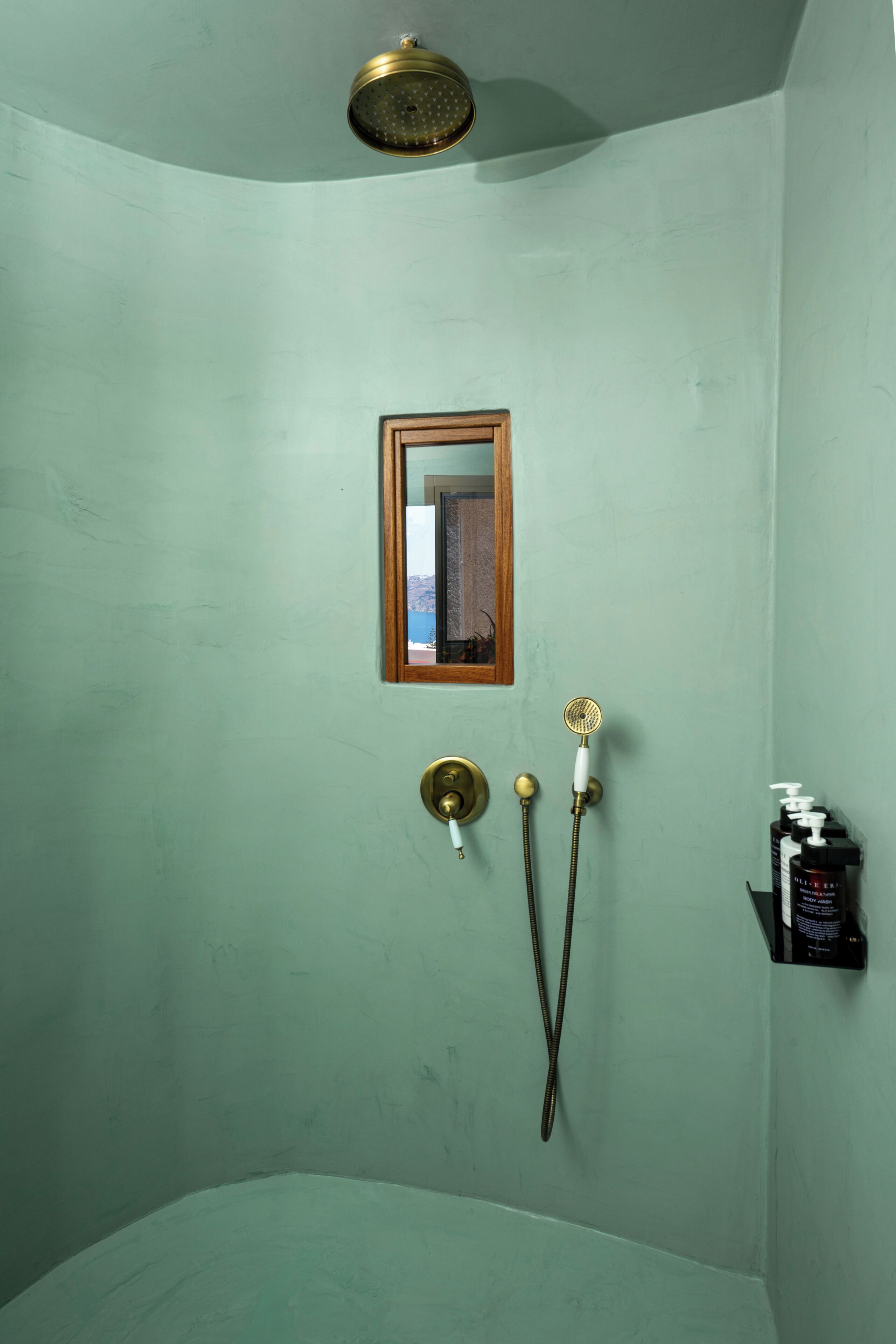 A bathroom with a shower, a mirror, and toiletries.