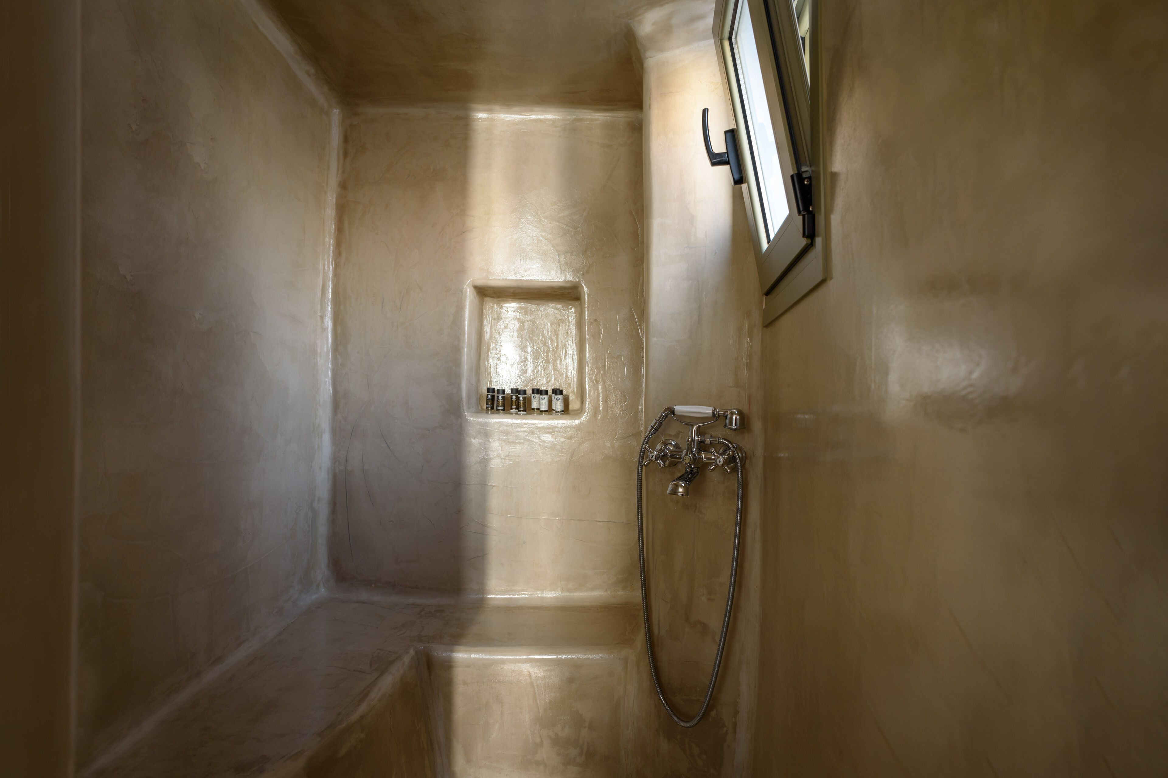 Ein kleines, separates Badezimmer mit Dusche, Spiegel und Fenster.