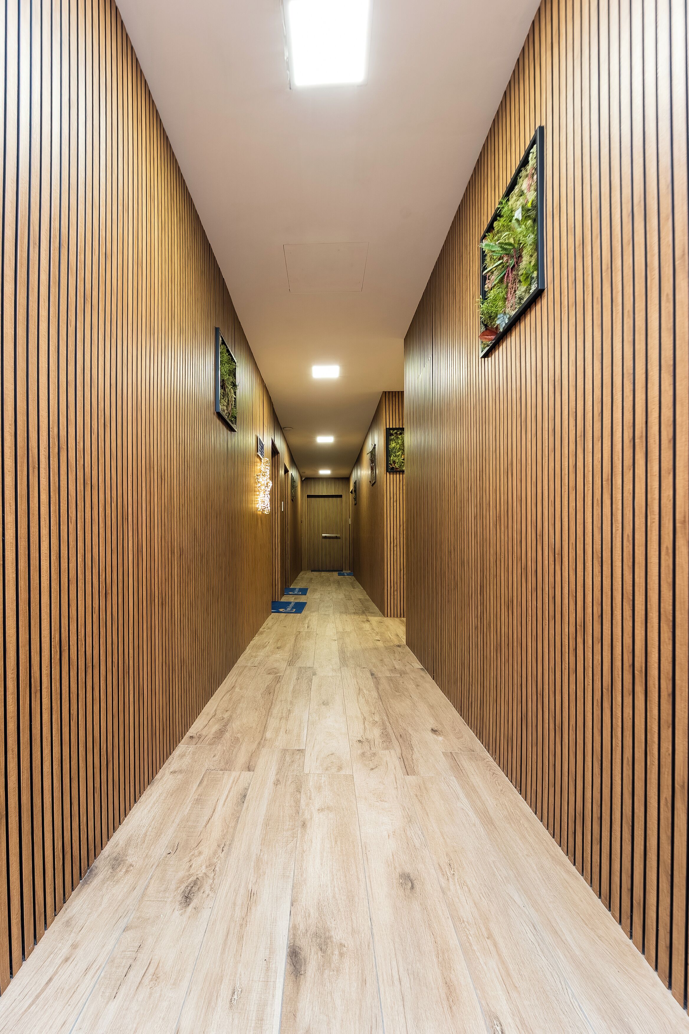 A hallway with wooden paneling and a wooden floor.