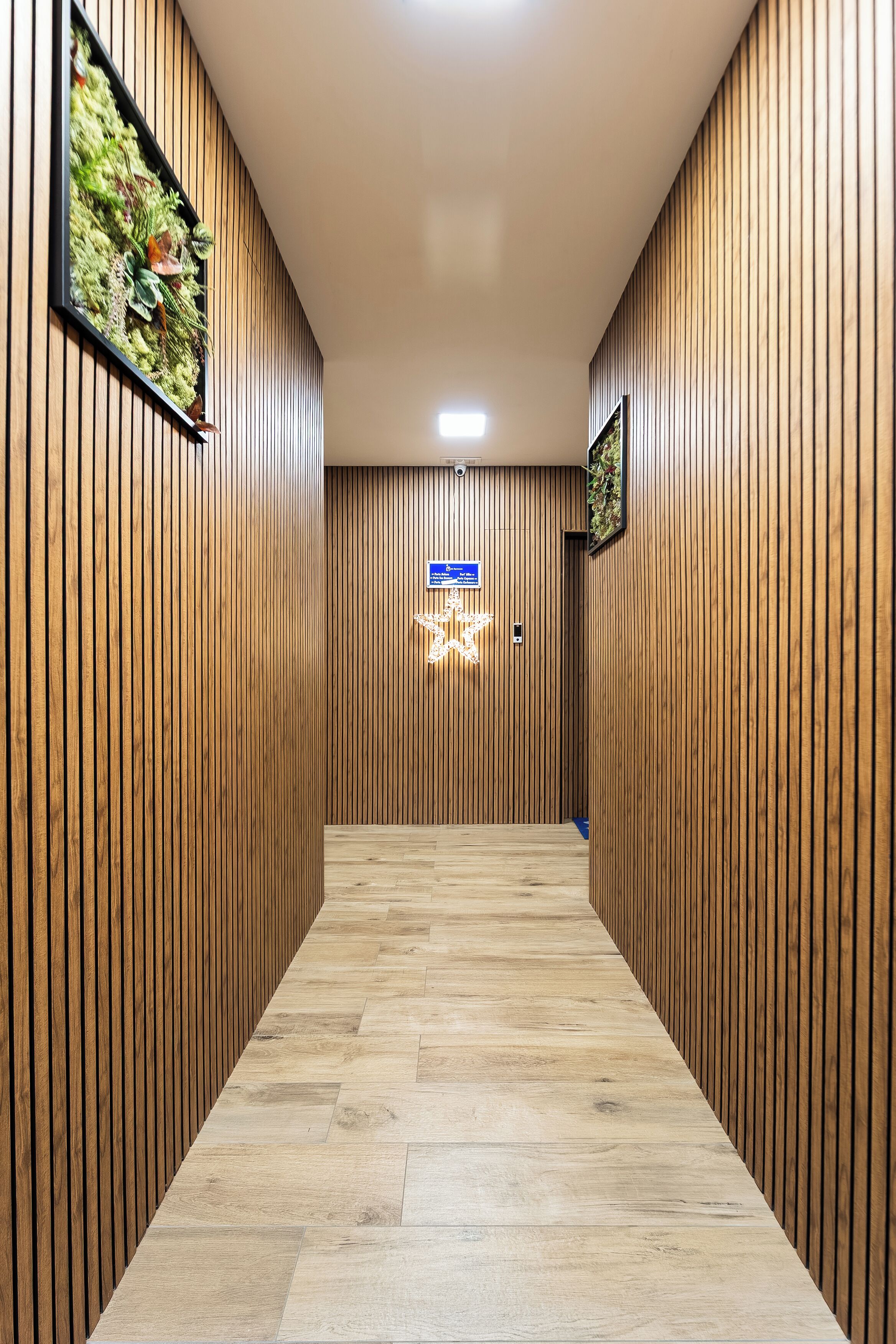 A hallway with wooden paneling, a star-shaped light fixture, and a sign on the wall.