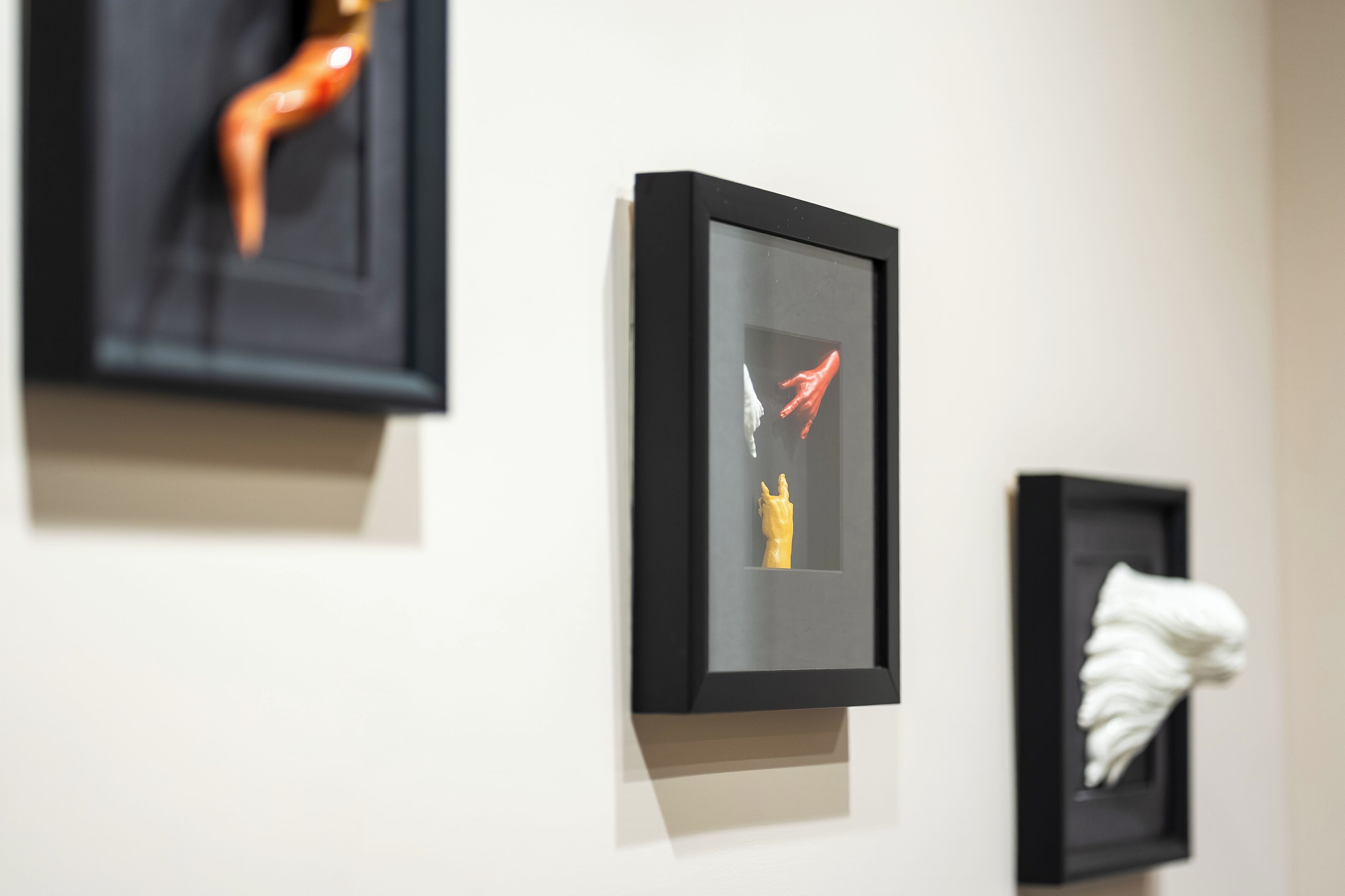 A wall with three framed artworks.