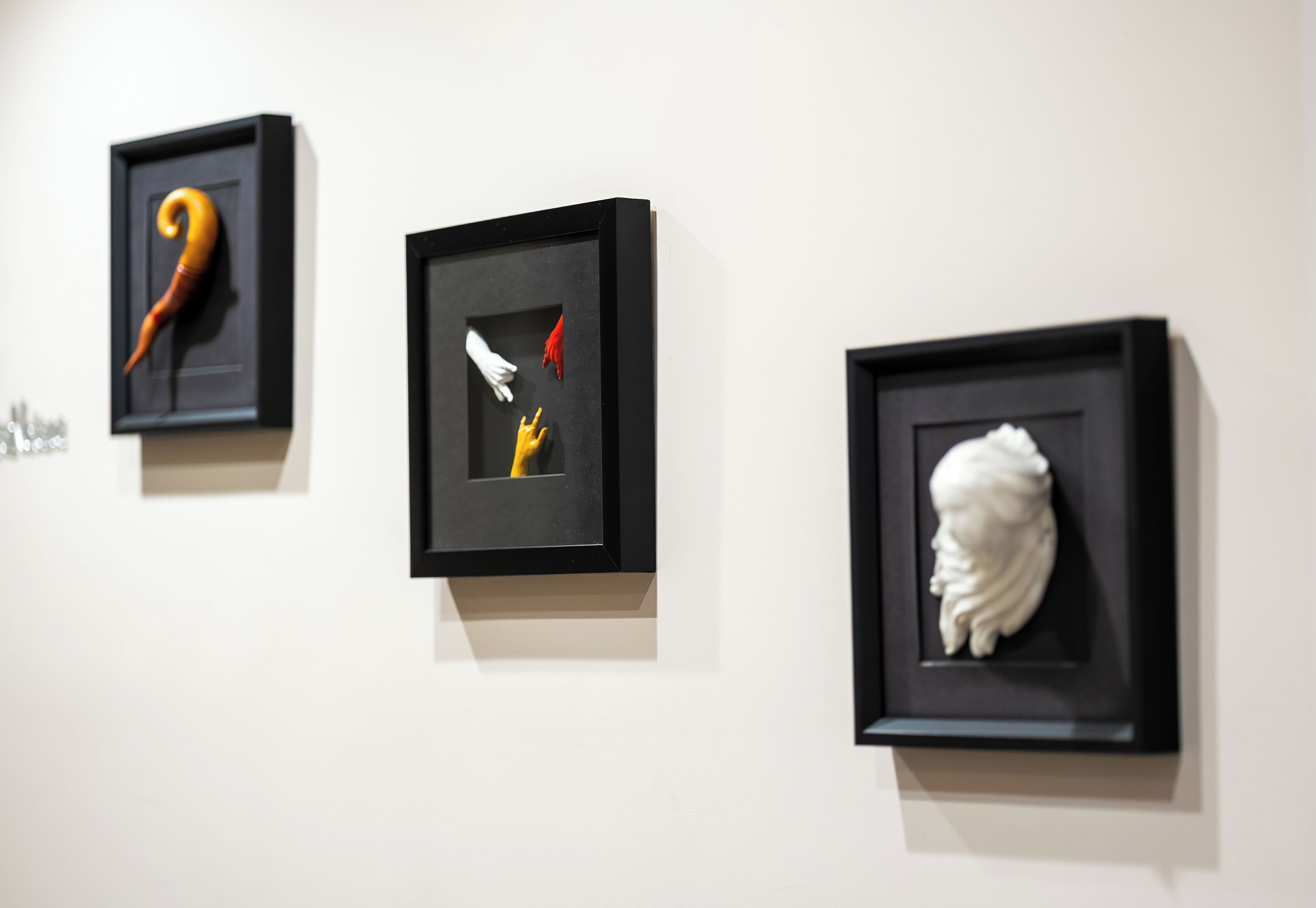 Three framed artworks on a wall.