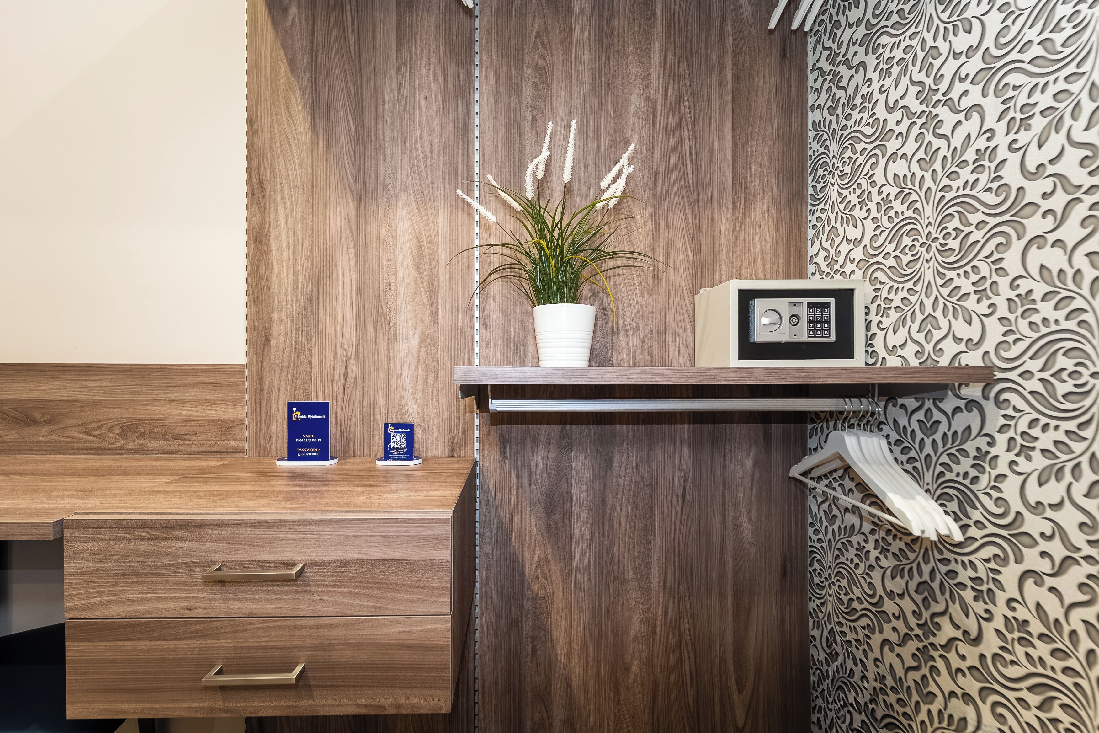 A wooden desk with a potted plant, a radio, and a blue booklet on the counter.