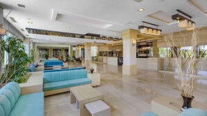 A spacious lobby with seating areas, a reception desk, and a view of the store area. - Telatiye Resort Hotel (Alanya)