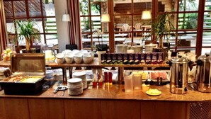A breakfast buffet with various food items, utensils, and condiments. - St Florian Hotel (Kaprun)