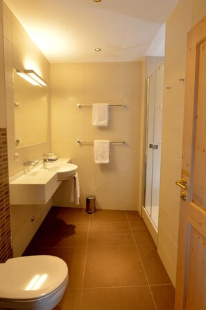A compact bathroom with a toilet, sink, and shower. - St Florian Hotel (Kaprun)