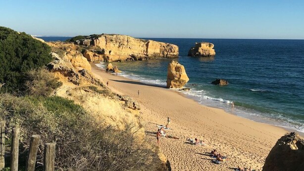 A coastal beach with rocky cliffs and clear blue sea. - Apartments Rio By Garvetur (Loulé)