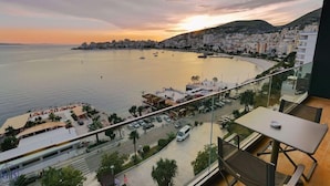 Paisatge urbà costaner amb vistes al mar, edificis i una zona d'aparcament.