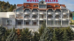 A hotel building with a sign reading "HOTEL EKLIPS" and a red flag on top. - Eklips Hotel (Farkë)