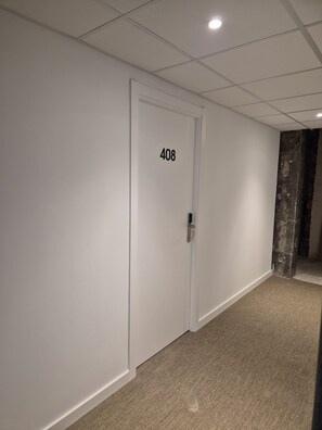A hallway with a carpeted floor, a white door with the number 408, and a ceiling with recessed lighting. - Hotel Calella by Beatriz Hoteles (Calella)