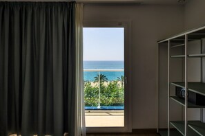 A room with a view of the sea, a balcony with a railing, and a shelving unit. - Hotel Calella by Beatriz Hoteles (Calella)