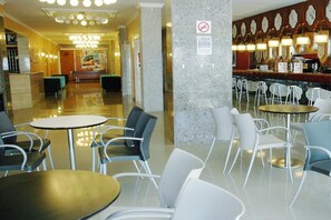 Un hall d’hôtel comprenant un comptoir d’accueil, un espace salon et un bar.