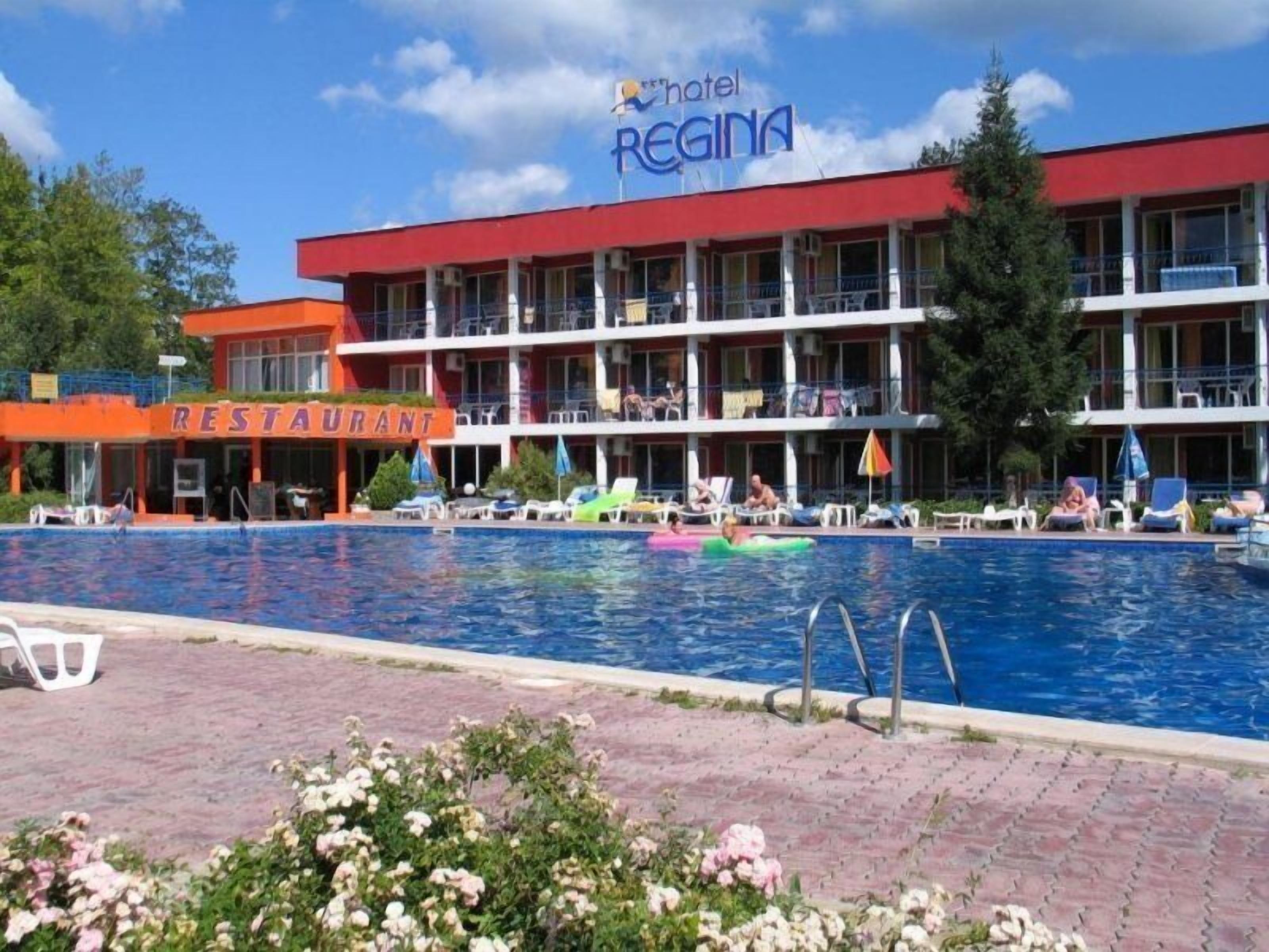 Un hotel con zona de piscina, restaurante y un cartel que dice 'Hotel Regina'.