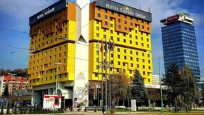 Um hotel com várias andares e fachada amarela marcante, chamado "Hotel Europa Group".