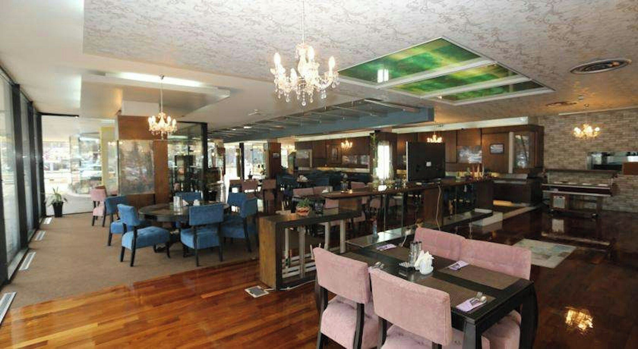A spacious hotel lobby with a bar area, seating arrangements, and a large window providing a view.