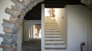 A stone staircase leading to a higher level, with a fire extinguisher on the right. - Proteas Studios (Naxos)