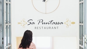 Una mujer entra en un restaurante llamado "Sa Puntassa".