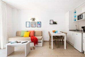 Un salon moderne avec un canapé, une table basse et un coin repas.