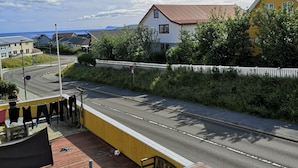 A view from a balcony overlooking a road with houses, a street sign, and a clear sky. - Rose Cottage 15m2 Tórshavn with Parking (Hoyvík)