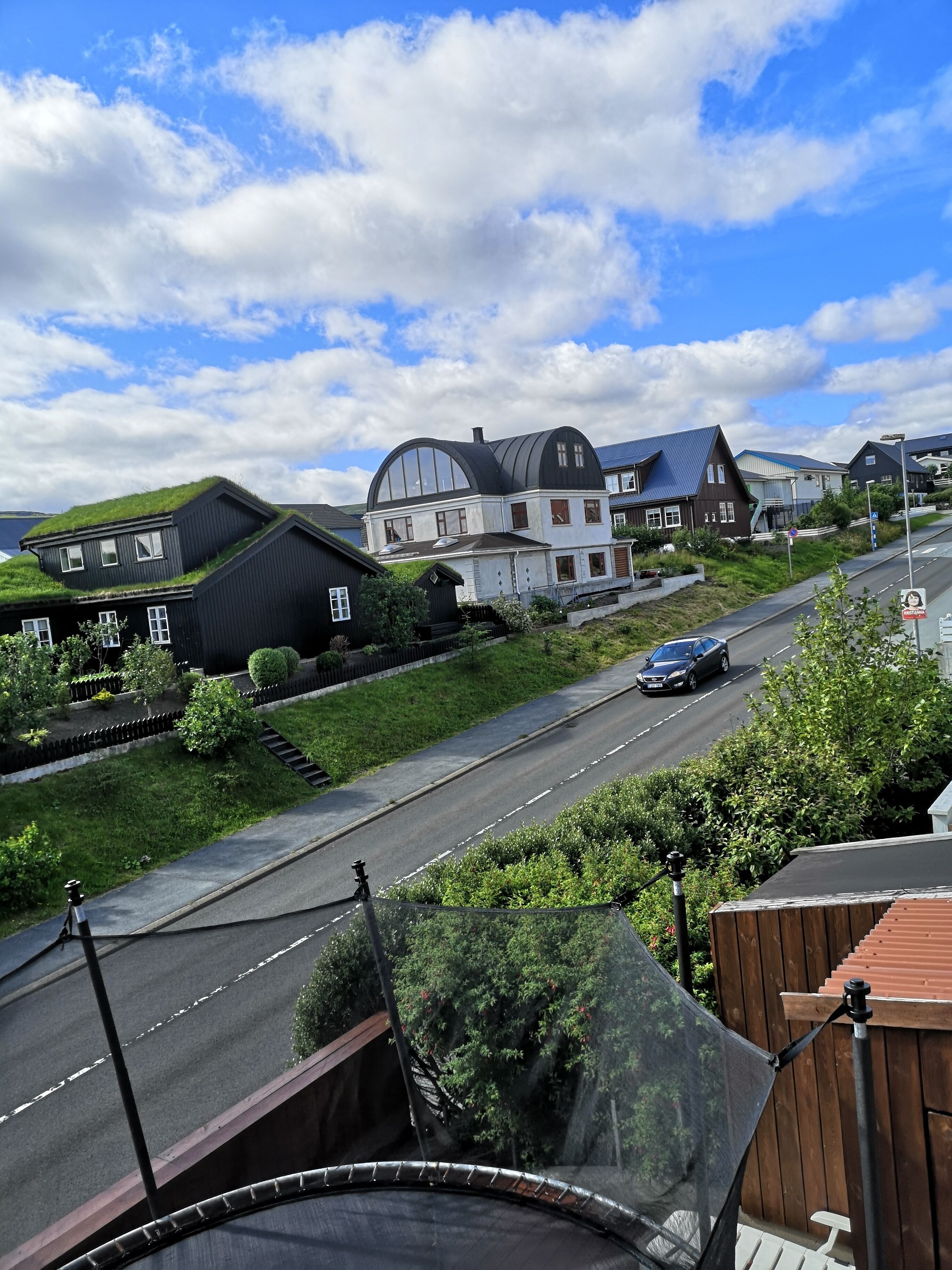 A residential area with houses, a road, and a clear sky.