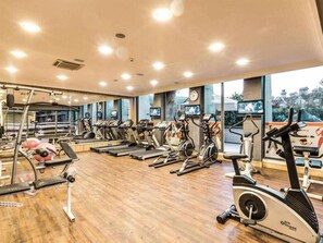 A gym with treadmills, elliptical machines, and a weight bench. - Grand Cettia (Marmaris)