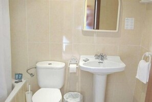 Un baño con inodoro, lavamanos y espejo.