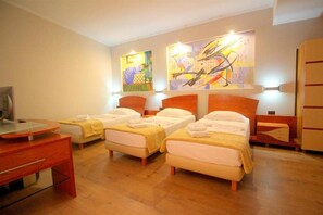 A hotel room with three single beds, a desk, and a television. - Saranda International Hotel (Sarandë)