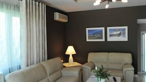 A modern living room with two sofas, a coffee table, a lamp, and two framed pictures on the wall. - Sokrat Hotel (Tirana)