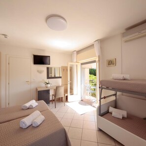 Habitación de hotel con dos camas, un escritorio, una silla, un televisor y un balcón.