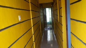 A narrow corridor with yellow walls and a tiled floor. - Golden Bay Hotel (Naivasha)