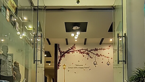Una escalera conduce a una zona de recepción con una pared decorativa y asientos.