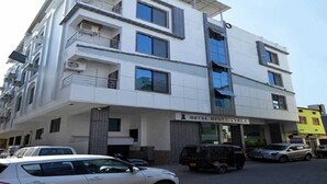Un hotel de varios pisos con fachada moderna, balcones y un letrero que indica que es un hotel.