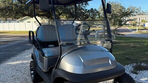 A golf cart parked on gravel.