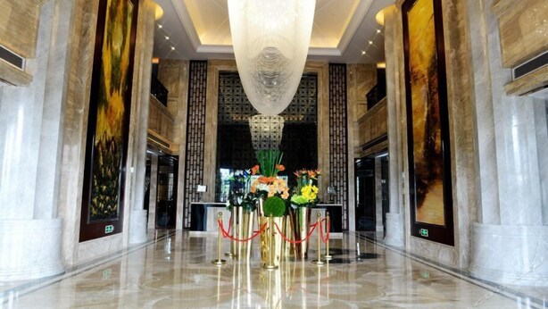 A spacious lobby with a high ceiling, marble columns, and a central chandelier. - Zhongshan Panshan Hotel (Zhongshan)