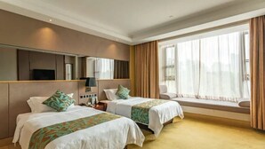 A hotel room with two beds, a large window with curtains, a bedside table with a lamp, and a TV mounted on the wall. - Zhongshan Panshan Hotel (Zhongshan)