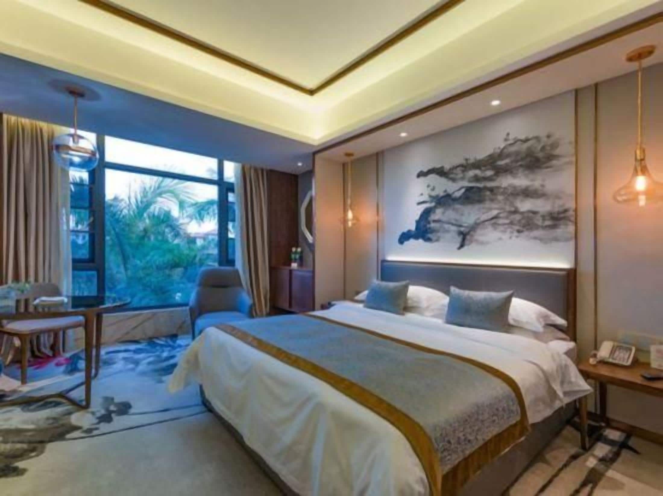 Une chambre d’hôtel moderne, dotée d’un grand lit, d’un bureau et offrant une vue sur l’extérieur.