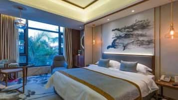 Habitación de hotel moderna con una cama grande, un escritorio y vistas al exterior.