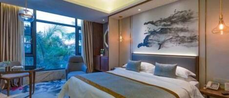 A modern hotel room with a large bed, a desk, and a view of the outdoors.