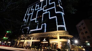 Un hotel moderno con una fachada geométrica llamativa e iluminación destacada.
